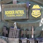 Feds WARN State: Hands Off Our Agents Border Patrol vest with gear and communication equipment.