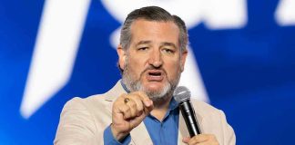 Man speaking passionately into a microphone on stage.