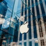 Apple’s Stock SHATTERS Record – Wall Street STUNNED Apple store with glass facade and city reflections.