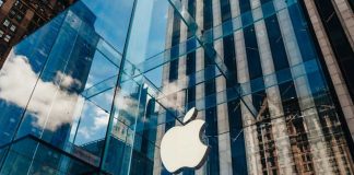 Apple’s Stock SHATTERS Record – Wall Street STUNNED Apple store with glass facade and city reflections.
