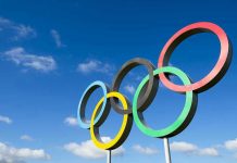 USA Olympians SUING Foundation – They’ve Had It! Olympic rings sculpture against blue sky.