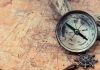 Ancient Treasure Surfaces – Prospectors BAFFLED! Old compass on a vintage map background.