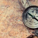 Ancient Treasure Surfaces – Prospectors BAFFLED! Old compass on a vintage map background.