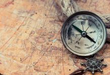 Ancient Treasure Surfaces – Prospectors BAFFLED! Old compass on a vintage map background.