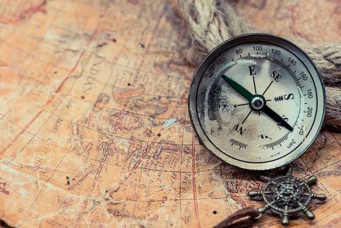 585543221 Old compass on a vintage map background.