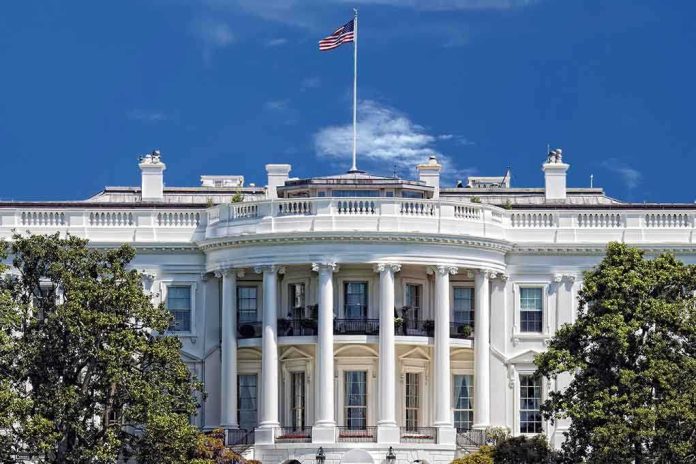 shutterstock_184005656.jpg The White House with the American flag flying against a blue sky