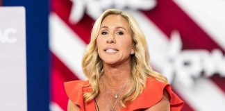 Woman speaking at an event, wearing a red dress.