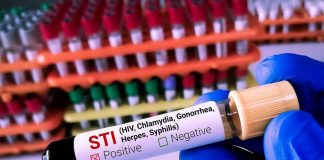 HIV Crisis Explodes – Children Left Defenseless Gloved hand holding STI test tube labeled Negative.