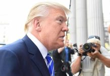 TRUMP EXPELS Nation From G20 – Historic First Man in suit with photographers in background.