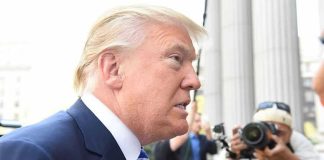 TRUMP EXPELS Nation From G20 – Historic First Man in suit with photographers in background.