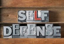 Homeowner Fires BLINDLY – Wrong Address TRAGEDY Metallic block letters spelling SELF DEFENSE on wooden shelves.