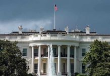 White House SLAMS Writer – Explosive Guard Shooting Debate White House with American flag and fountain, stormy sky.
