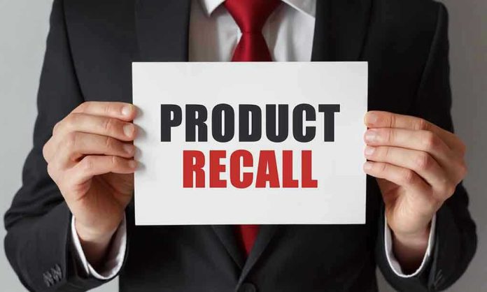 Product Recall sign held by person in suit.