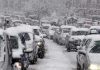 Winter Storm PARALYZES Nation – Thanksgiving Chaos Explodes Traffic jam with cars covered in heavy snow during a snowstorm