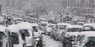 Winter Storm PARALYZES Nation – Thanksgiving Chaos Explodes Traffic jam with cars covered in heavy snow during a snowstorm