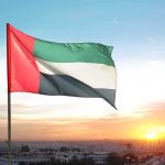 United Arab Emirates flag waving against a sunset backdrop