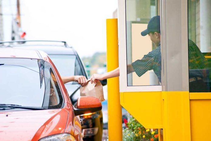 shutterstock_38753656.jpg Customer receiving a food order at a drive-thru window