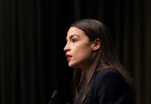 AOC LOSES IT During Congressional Hearing – Woah! Person speaking at a podium side profile view