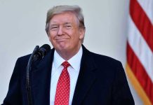 Trump Hints at GENEROUS Handouts: Fiscal Ruin or Relief? Man in suit and tie speaking at podium.