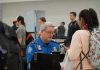 HIDDEN Program Turns Airports Into Deportation Centers TSA agent checks passengers documents at airport security.
