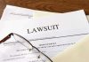 Documents labeled Lawsuit with glasses on top.