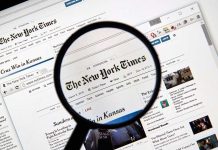 Magnifying glass over The New York Times website.