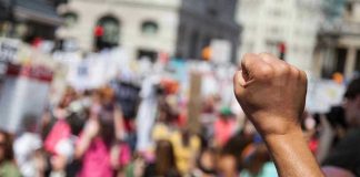Raised fist in front of a crowd.