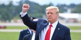 US Allies Praise Trump’s Capture of Corrupt Dictator Man in suit raising fist near parked car.