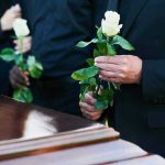 2-Time Presidential Hopeful, Dies Aged 84 Mourners holding white roses by a casket.