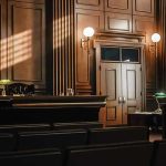 Rogue Judge CONVICTED After Courtroom Stunt Backfired Empty courtroom with judges bench and wooden decor.