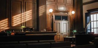Rogue Judge CONVICTED After Courtroom Stunt Backfired Empty courtroom with judges bench and wooden decor.