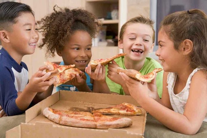 Children happily eating pizza together.