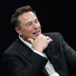 Musk’s Lawsuit EXPOSES OpenAI’s Hidden Agenda Man in suit smiling, resting chin on hand.