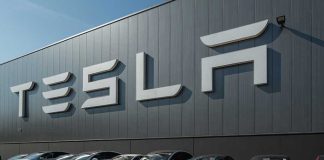 Tesla facility with parked cars in front.