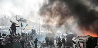 Massive Missile Barrage Pummels Ukraine—What’s Next? A chaotic protest scene with smoke, fire, and people holding flags