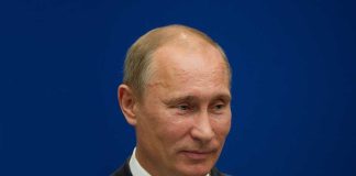 China-Russia Pact: America’s New Nightmare? A political figure speaking at a press conference against a blue background