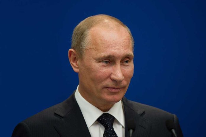 A political figure speaking at a press conference against a blue background