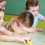 Unchecked AI Toys Misreading Kids! Children at a table with building blocks, one child appears upset