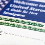 A guide for new immigrants alongside permanent resident cards and an American flag