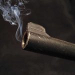 Pre-Prom Gathering Turns Deadly: What Went Wrong? Close-up of a gun barrel emitting smoke against a black background
