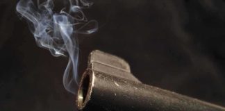 Pre-Prom Gathering Turns Deadly: What Went Wrong? Close-up of a gun barrel emitting smoke against a black background