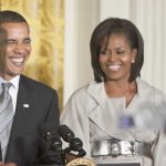 Obama’s Colbert Comment Sparks Debate Former President Barack Obama and Michelle Obama smiling at a public event