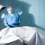 Doctor in scrubs examining patient in hospital room