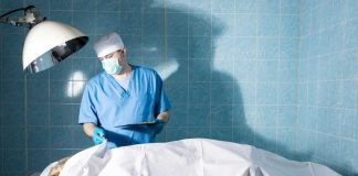 Doctor in scrubs examining patient in hospital room