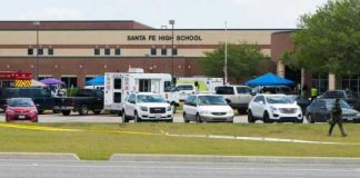 High school parking lot with emergency vehicles and tents