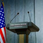 Judge Slaps Down Vaccine Panel Overhaul Press podium with the White House sign and an American flag in the background