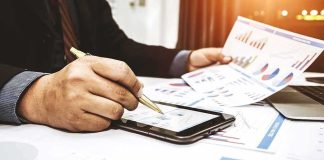 The Wealth Tax That Could Raise Trillions Businessperson analyzing charts with tablet and papers