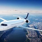 World Cup Sky Turns Combat Zone White regional jet flying over a city and river