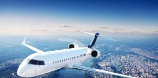 White regional jet flying over a city and river