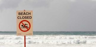 The Truth About Britain’s Beach Threats Sign indicating the beach is closed with a no swimming symbol